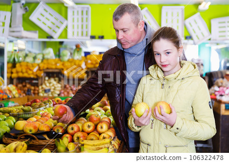 girl with father choosing ripe apples girl with father choosing ripe apples 106322478