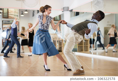 Woman with african man practising charleston dancing Woman with african man practising charleston dancing 106322578