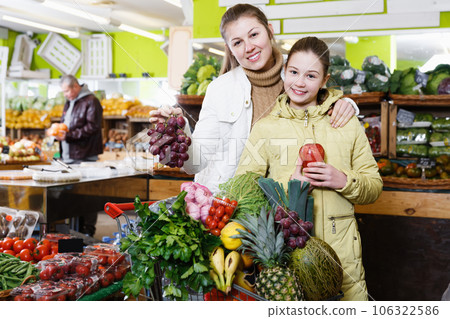 Daughter with young mother choosing fresh delicious fruits in store 106322586