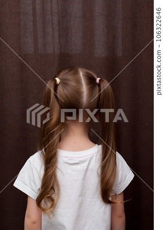 Girl's hairstyle braided in a braid fixed with a blue elastic band close-up. Hair styling is done with hairpins and an elastic band. Only the back of the head with a haircut Girl's hairstyle braided in a braid fixed with a blue elastic band close-up. Hair styling is done with hairpins and an elastic band. Only the back of the head with a haircut 106322646