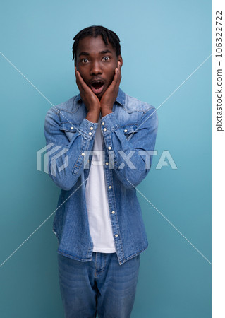 portrait of a surprised young cheerful american man with dreadlocks in a denim jacket portrait of a surprised young cheerful american man with dreadlocks in a denim jacket 106322722