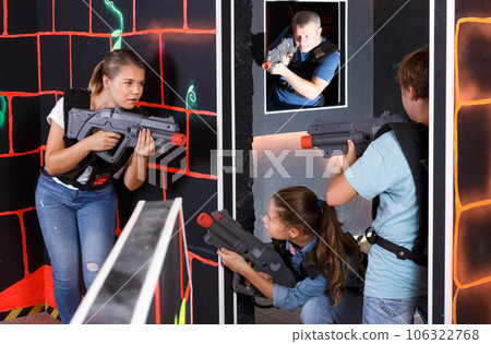 Smiling children with theirs parents holding laser guns during laser tag game 106322768