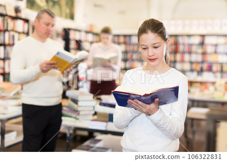 Little girl visiting bookstore with parents 106322831