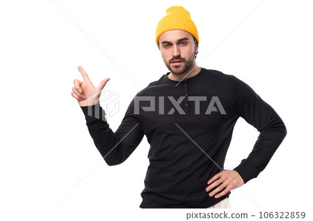 a brutal handsome young 30 year old guy dressed in a black jacket and a yellow hat points to the a brutal handsome young 30 year old guy dressed in a black jacket and a yellow hat points to the 106322859