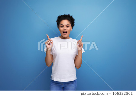 well-groomed beautiful young swarthy woman with fluffy curly hair dressed in a white T-shirt speaks well-groomed beautiful young swarthy woman with fluffy curly hair dressed in a white T-shirt speaks 106322861