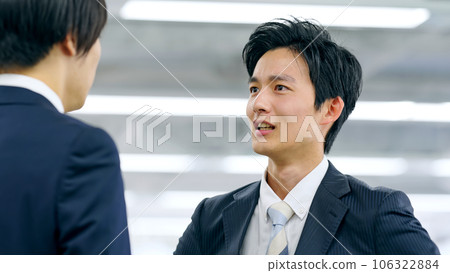 Young businessman talking to colleague with a cheeky attitude 106322884