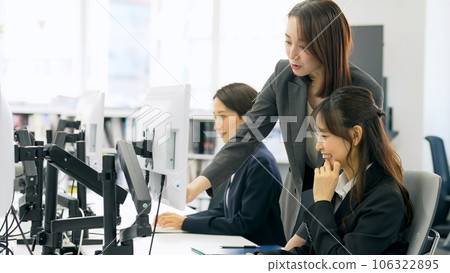 A mid-level business woman guiding young employees 106322895