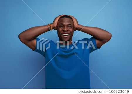 A 30 year old dark-skinned American man dressed in a basic T-shirt poses in front of copy space A 30 year old dark-skinned American man dressed in a basic T-shirt poses in front of copy space 106323049