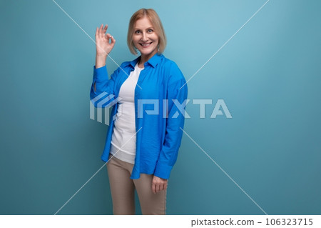50s woman in blue shirt with idea on blue background with copy space 50s woman in blue shirt with idea on blue background with copy space 106323715