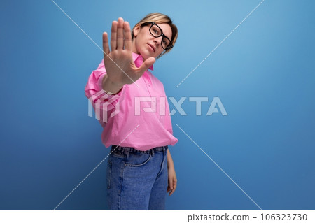 young serious caucasian blonde secretary woman with ponytail hairstyle, glasses and in a pink shirt 106323730
