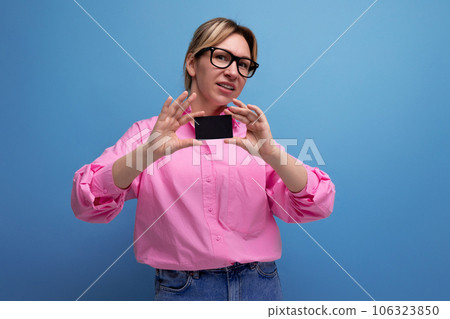 young caucasian blonde secretary woman with ponytail hairstyle and glasses dressed in a pink shirt 106323850