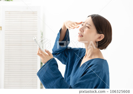 A woman who is worried about the temperature of the air conditioner 106325608