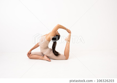 Girl doing stretching in the studio on a white background. A beautiful gymnast with a flexible body and athletic uniform Girl doing stretching in the studio on a white background. A beautiful gymnast with a flexible body and athletic uniform 106326203