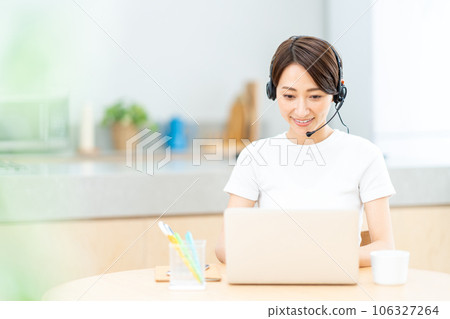 A middle-aged woman who teleworks in the living room. A middle-aged woman who teleworks in the living room. 106327264