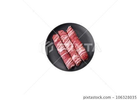 Raw minced meat wrapped in bacon with salt and spices or cevapcici 106328035