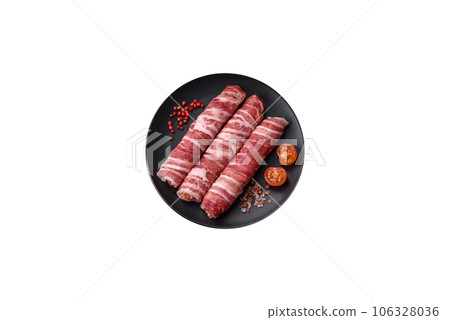 Raw minced meat wrapped in bacon with salt and spices or cevapcici 106328036