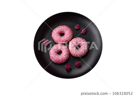 Delicious fresh sweet donuts in pink glaze with strawberry filling Delicious fresh sweet donuts in pink glaze with strawberry filling 106328052