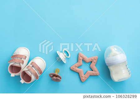 Flat lay of infant items on serene blue, top perspective offering spaciousness 106328299