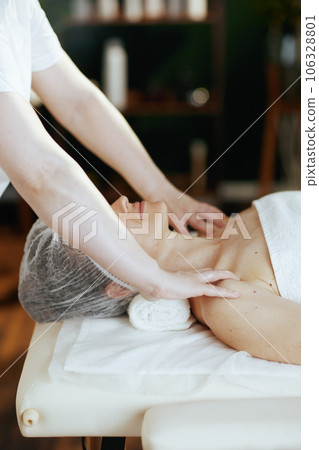 massage therapist massaging clients shoulder on massage table massage therapist massaging clients shoulder on massage table 106328801