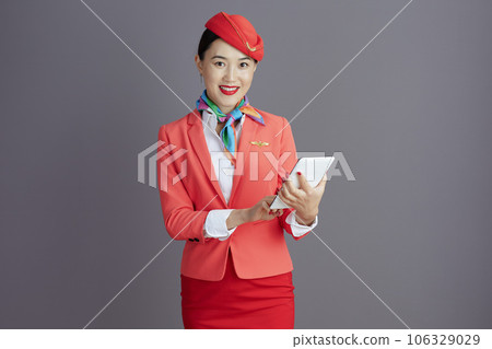 smiling stylish air hostess asian woman against gray background 106329029