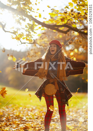 smiling young woman in red hat with scarf and gloves rejoicing smiling young woman in red hat with scarf and gloves rejoicing 106329381