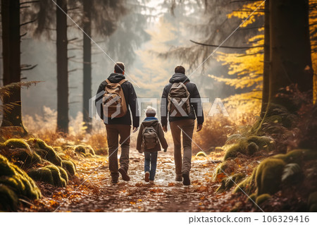 Faceless family walking hike through colorful autumn forest. Rear view of parents and child walking on trail Faceless family walking hike through colorful autumn forest. Rear view of parents and child walking on trail 106329416