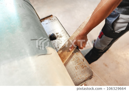 Close-up of carpenter's hands working with wood piece in a workshop Close-up of carpenter's hands working with wood piece in a workshop 106329664