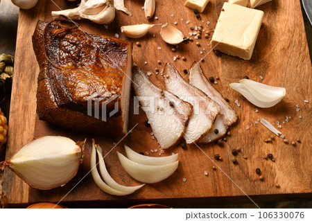 still life of food in a rural style on a dark wood background, sliced lard and garlic, cheese and onion, concept of fresh vegetables and healthy food still life of food in a rural style on a dark wood background, sliced lard and garlic, cheese and onion, concept of fresh vegetables and healthy food 106330076