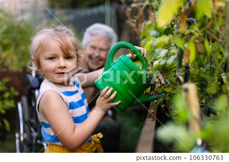 Portrait of a little adorable girl helping her grandmother in the garden. Portrait of a little adorable girl helping her grandmother in the garden. 106330763
