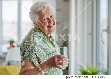 Senior woman drinking water to better manage her diabetes. 106330808