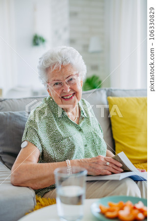 Diabetic senior patient using continuous glucose monitor to check blood sugar level at home. 106330829