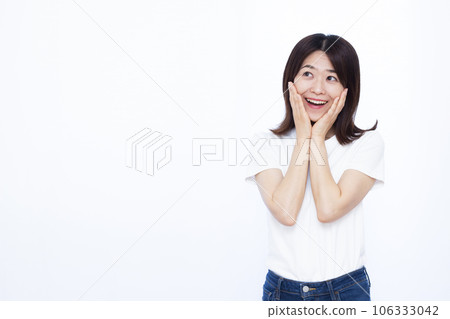 一個三十多歲的女人,在白色背景前微笑著感到驚訝 一個三十多歲的女人,在白色背景前微笑著感到驚訝 106333042