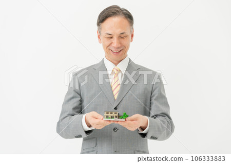 Businessman with housing model Businessman with housing model 106333883