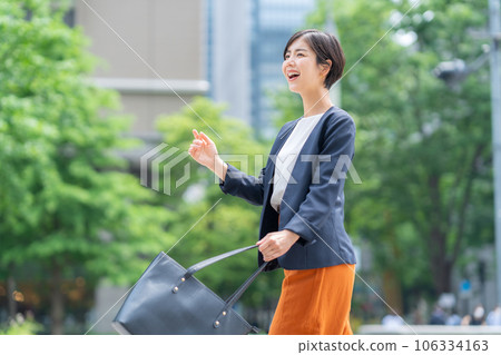 Young business woman in office casual commuting to office district Young business woman in office casual commuting to office district 106334163