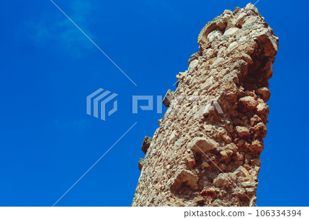 an ancient stone tower on a blue sky background 106334394