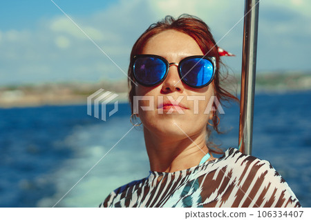 beautiful girl with glasses on the background of the sea 106334407