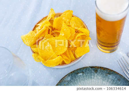 Potato chips and beer served on table Potato chips and beer served on table 106334614