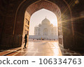 tourist standing in front entrance gate of Taj Mahal indian palace. Islam architecture. Door to the mosque  106334763