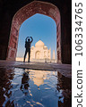tourist standing in front entrance gate of Taj Mahal indian palace. Islam architecture. Door to the mosque  106334765