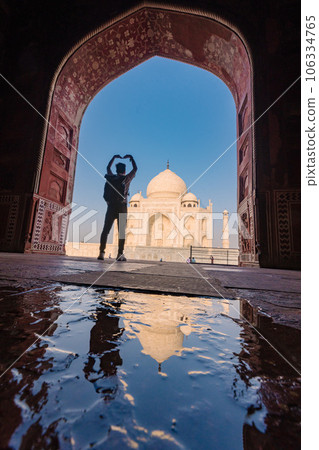 tourist standing in front entrance gate of Taj Mahal indian palace. Islam architecture. Door to the mosque  106334765