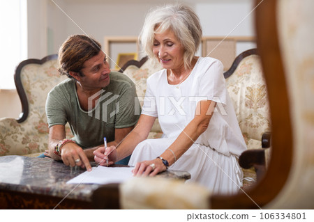 Mature woman and man doing paperwork together Mature woman and man doing paperwork together 106334801