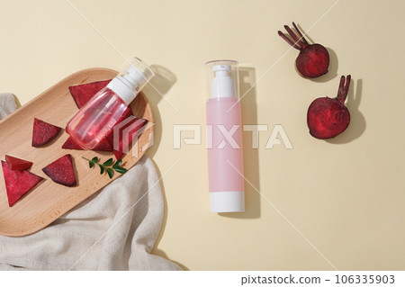 Pump bottle dispenser decorated with fresh beetroot slices. Mockup design with empty label. Beetroot (Beta vulgaris) reduces acne and blemishes 106335903