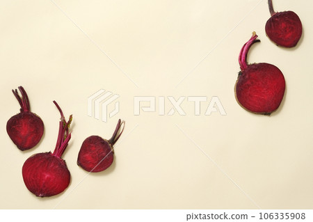 Minimal scene of fresh beetroot cut in halves decorated against beige background. Empty space to display product extracted from Beetroot (Beta vulgaris) 106335908