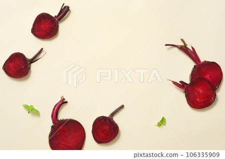 Slices of beetroot are arranged with small green leaves over light background. Beetroot (Beta vulgaris) may delay signs of premature aging 106335909