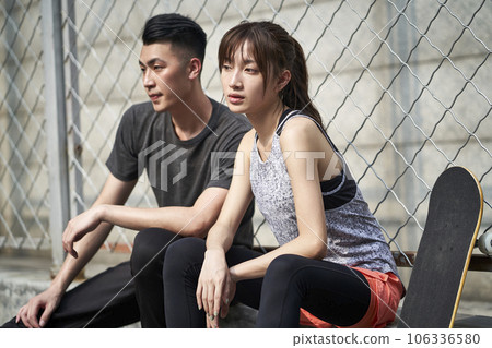 young asian adult couple man and woman resting relaxing outdoors after exercise 106336580