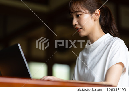 A woman using a computer in an old folk house 106337493