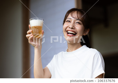 Cute woman drinking beer with a smile Cute woman drinking beer with a smile 106337676