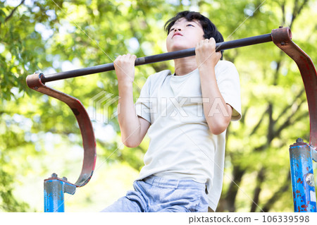 Elementary school boys doing pull-ups Elementary school boys doing pull-ups 106339598