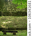 Background material of a stone wall and a bench in the shade of a tree, vertical position. 106341681