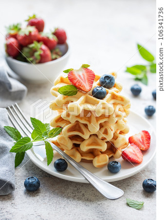 Freshly baked waffles with strawberries and blueberries 106341736